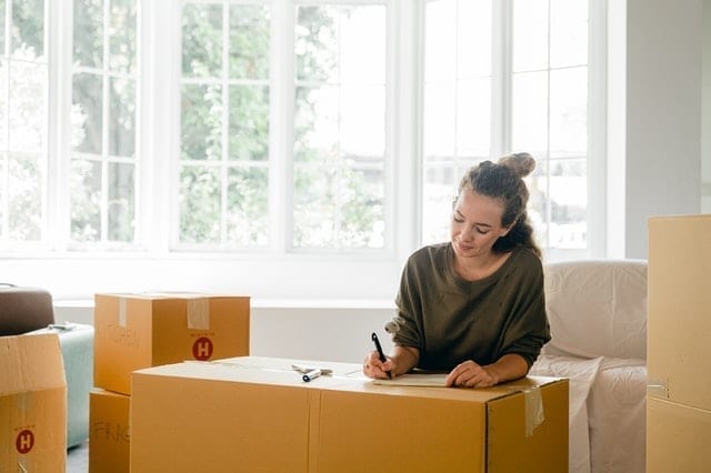 a woman labeling boxes, showing why you should hire a professional organizer for your new Tennessee home