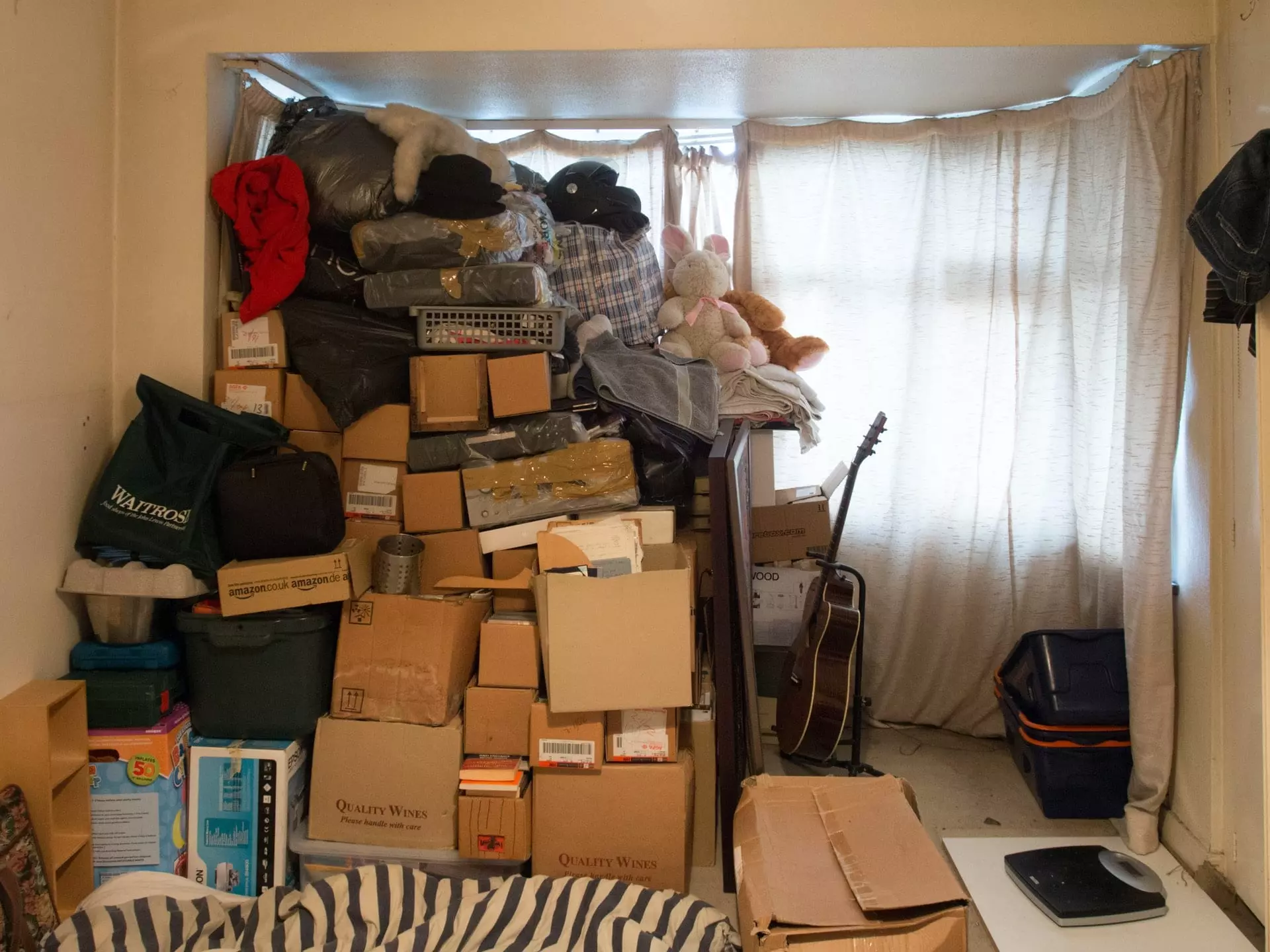 A cluttered room full of unpacked boxed