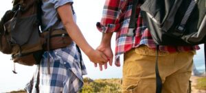 A couple holding hands while on a hike