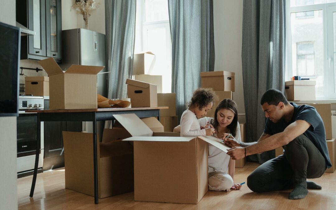 Parents with their daughter packing their things because they are moving to a new home.