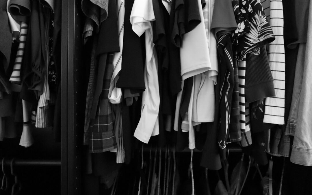Everyday shirts and clothing hanging closely together in a closet
